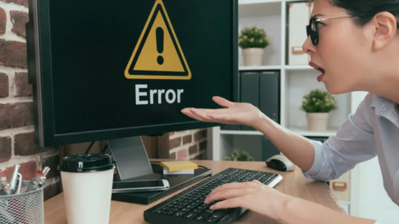Mujer frente a un monitor con un mensaje de error del sitio web